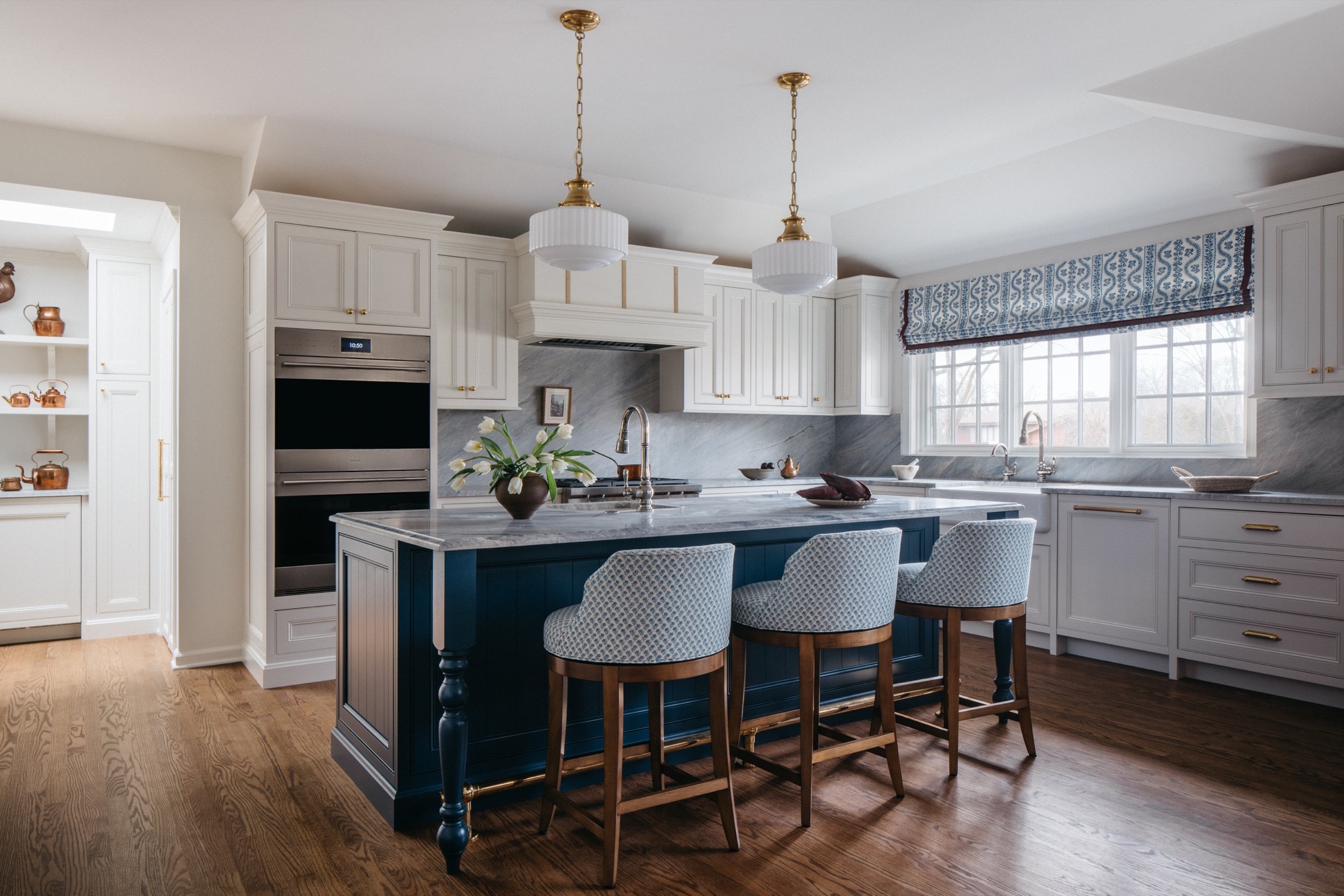 Cream kitchen with navy island and brass pendants by Leah Phillips Interiors