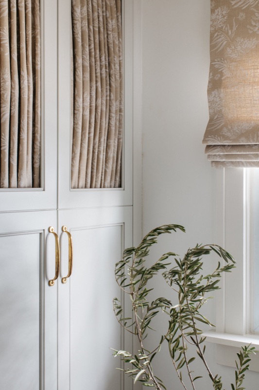Linen-front wardrobe cabinets with brass hardware, a detail by Leah Phillips Interiors