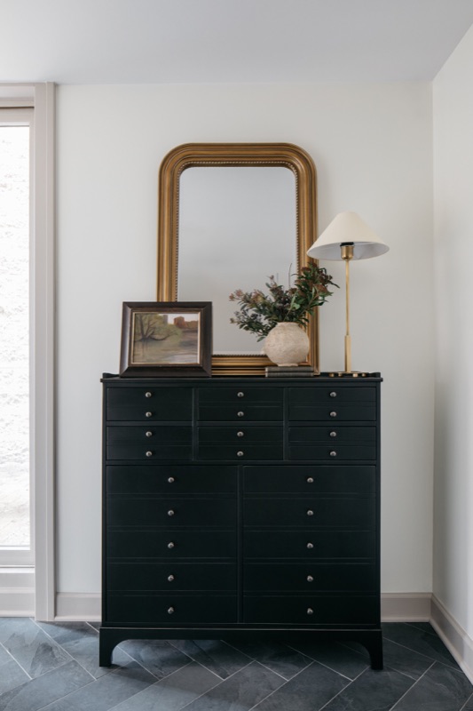 Black dresser vignette with gold mirror and ceramic lamp designed by Leah Phillips Interiors