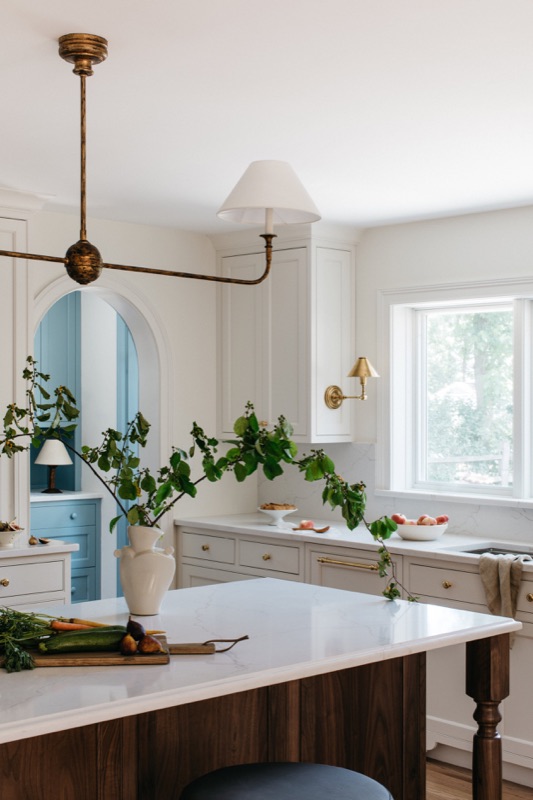 Kitchen with walnut island and arched blue pantry designed by Leah Phillips Interiors