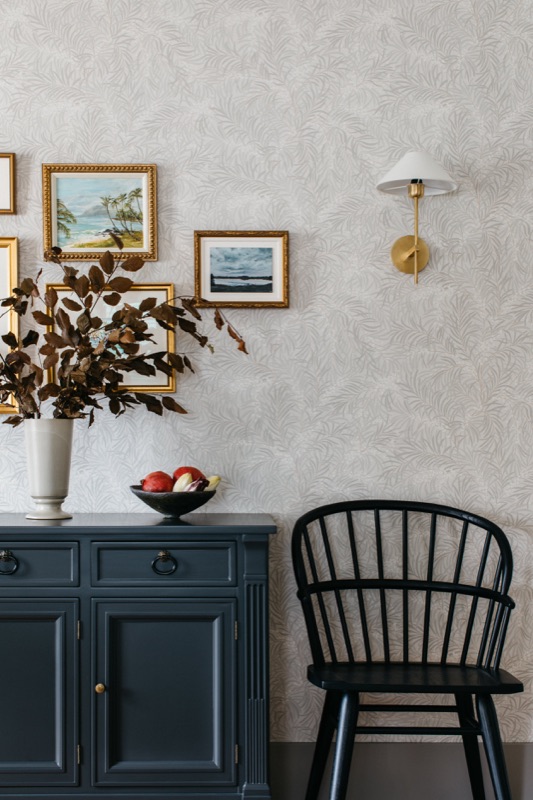 Hall console in navy beneath textured wallpaper · Downers Grove Main Level Renovation by Leah Phillips Interiors
