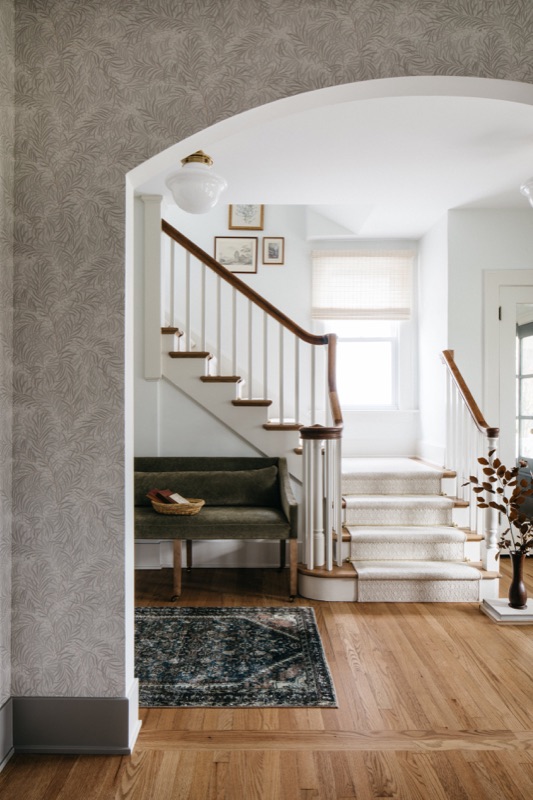 Staircase with patterned runner and soft gray wallpaper · Downers Grove Main Level Renovation by Leah Phillips Interiors