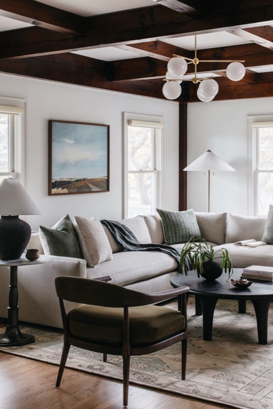 Family room with coffered dark-beam ceiling and layered neutrals · Downers Grove Main Level Renovation by Leah Phillips Interiors