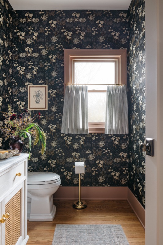 Powder room wrapped in dark botanical wallpaper · Downers Grove Main Level Renovation by Leah Phillips Interiors