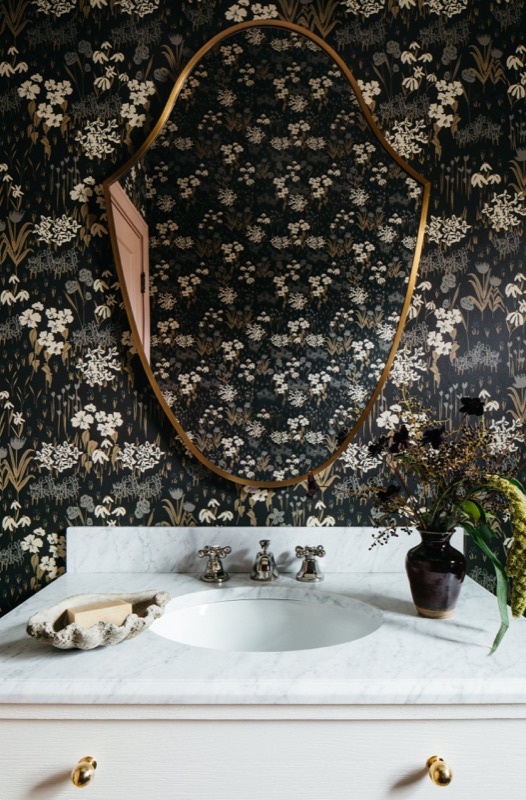 Powder room detail with sculptural brass mirror · Downers Grove Main Level Renovation by Leah Phillips Interiors