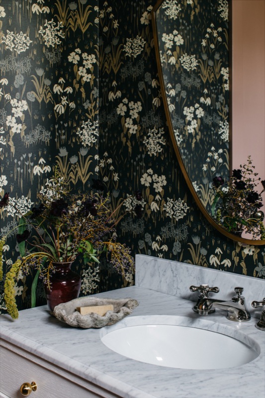 Marble-topped powder vanity with moody botanical wallpaper · Downers Grove Main Level Renovation by Leah Phillips Interiors