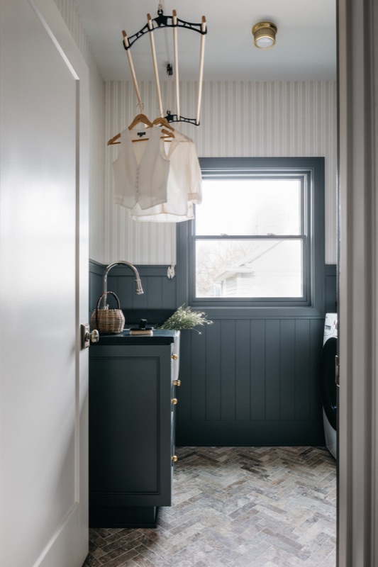 Navy laundry with herringbone tile floor and task window · Downers Grove Main Level Renovation by Leah Phillips Interiors