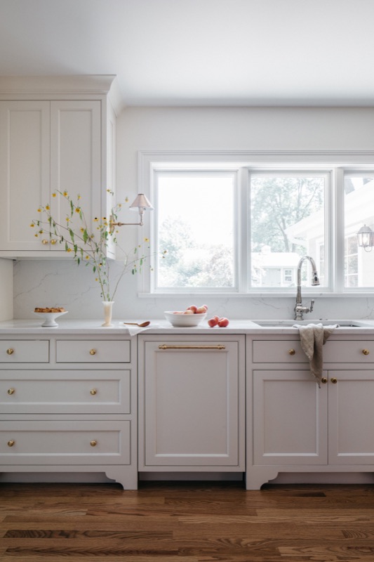 Cream perimeter cabinetry with marble counters and farm sink · Glen Ellyn Kitchen & Bathroom Renovation by Leah Phillips Interiors