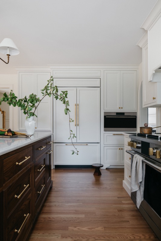Kitchen with paneled refrigerator and dark walnut island · Glen Ellyn Kitchen & Bathroom Renovation by Leah Phillips Interiors