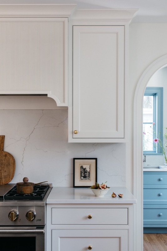 Range wall with cream cabinetry and arched marble niche · Glen Ellyn Kitchen & Bathroom Renovation by Leah Phillips Interiors