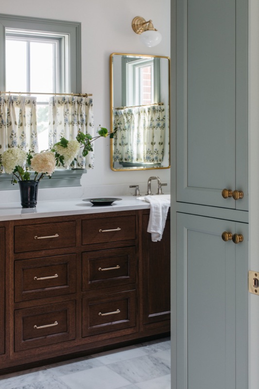 Walnut vanity with sage green cabinetry and marble floor · Glen Ellyn Kitchen & Bathroom Renovation by Leah Phillips Interiors