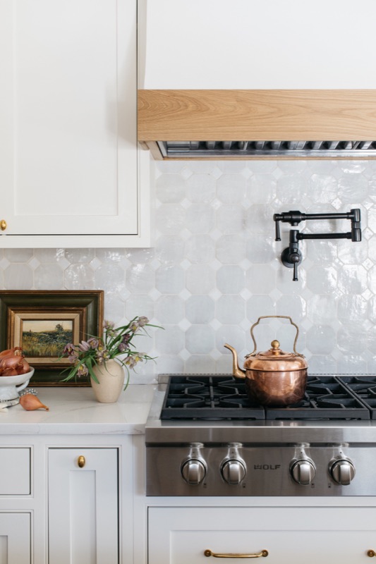 Range detail with copper kettle and marble ledge · Glen Ellyn Main Level Renovation by Leah Phillips Interiors