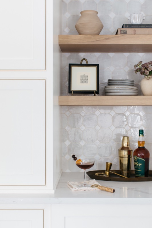 Styled bar shelves with art and glassware · Glen Ellyn Main Level Renovation by Leah Phillips Interiors