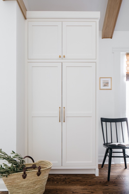 Full-height white pantry cabinets with brass knobs · Glen Ellyn Main Level Renovation by Leah Phillips Interiors