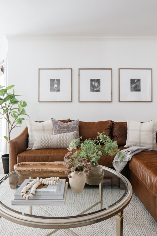 Living room with cognac leather sofa and glass coffee table · Glen Ellyn Main Level Renovation by Leah Phillips Interiors