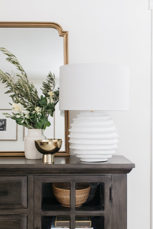 Dark wood console with ribbed lamp and olive branches · Glen Ellyn Main Level Renovation by Leah Phillips Interiors