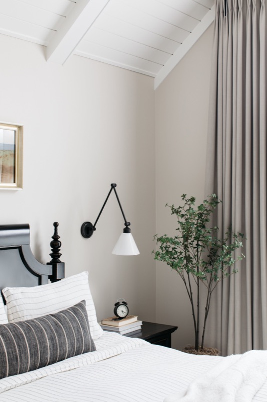 Bedside view with sconce and soft drapery · Glen Ellyn Main Level Renovation by Leah Phillips Interiors