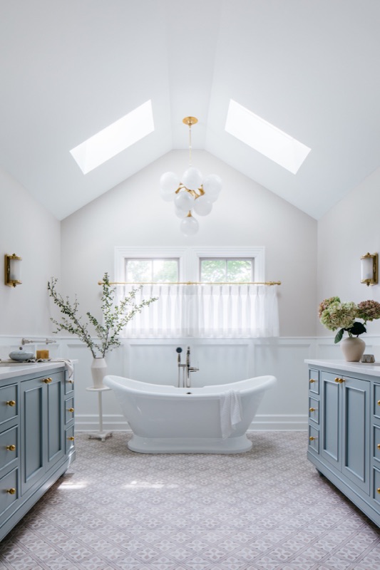 Vaulted bath with twin vanities flanking the freestanding tub · Glen Ellyn Primary Bathroom Renovation by Leah Phillips Interiors