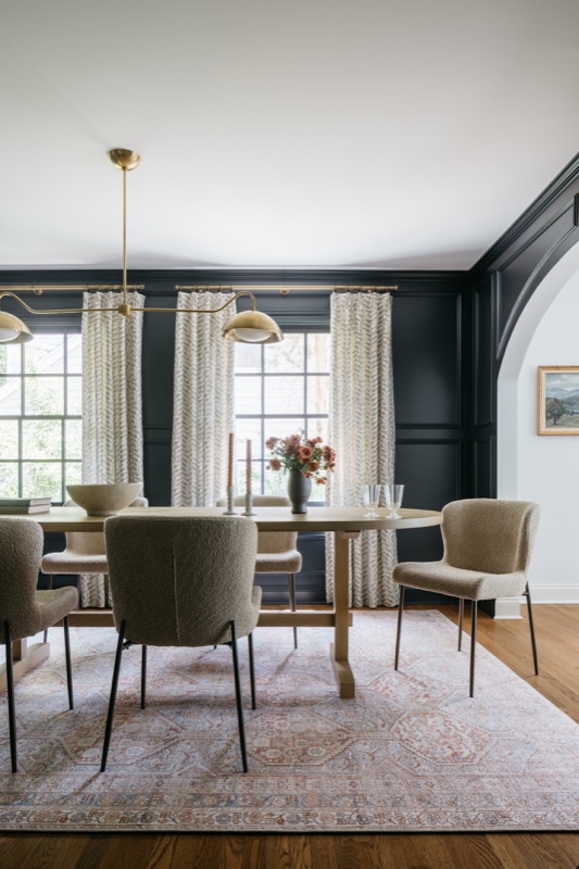 Dining room with black paneled walls and olive velvet chairs · Glenview Home Renovation