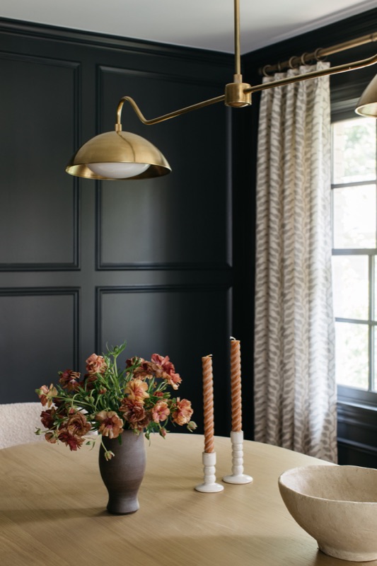Black paneled den detail with brass library sconce · Glenview Home Renovation by Leah Phillips Interiors