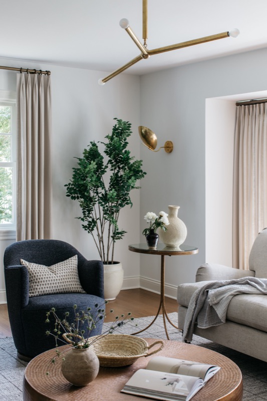 Living room with swivel chairs and brass mobile chandelier · Glenview Home Renovation by Leah Phillips Interiors