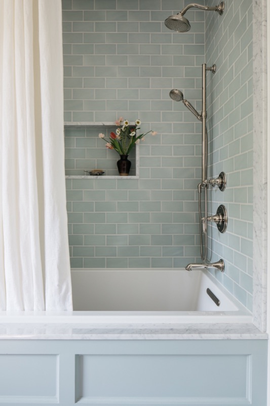 Bathroom with sage subway tile tub surround · Glenview Home Renovation by Leah Phillips Interiors