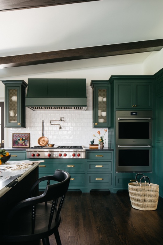 Range wall with white tile, green cabinetry and double ovens · Glenview Kitchen Addition & Renovation by Leah Phillips Interiors