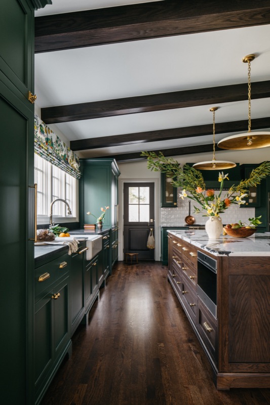 Long view of the green kitchen toward the garden window · Glenview Kitchen Addition & Renovation by Leah Phillips Interiors