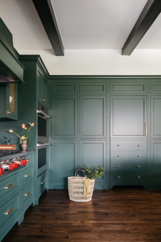 Floor-to-ceiling green storage wall with market basket · Glenview Kitchen Addition & Renovation by Leah Phillips Interiors