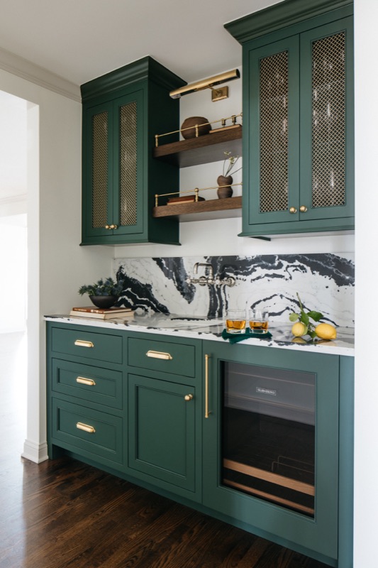 Green bar cabinet with dramatic marble backsplash · Glenview Kitchen Addition & Renovation by Leah Phillips Interiors
