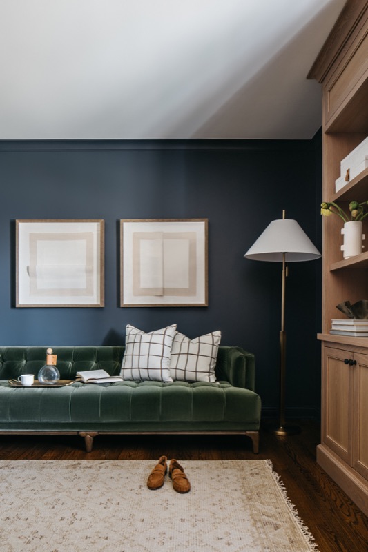 Den with navy walls and green velvet daybed · Glenview Kitchen Addition & Renovation by Leah Phillips Interiors