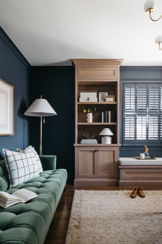 Office lounge with green sofa and walnut built-ins · Glenview Kitchen Addition & Renovation by Leah Phillips Interiors