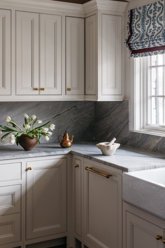 Corner detail of cream cabinetry with brass hardware and farm sink · Glenview Main Level Renovation by Leah Phillips Interiors