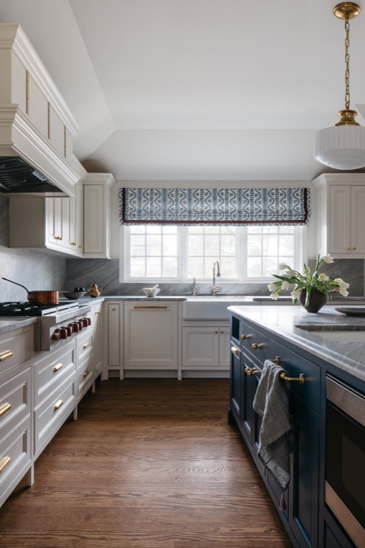 View down the galley kitchen toward the patterned roman shade · Glenview Main Level Renovation by Leah Phillips Interiors