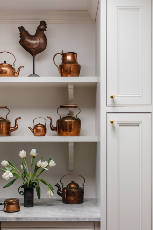 Open shelving styled with a collected display of copper kettles · Glenview Main Level Renovation by Leah Phillips Interiors