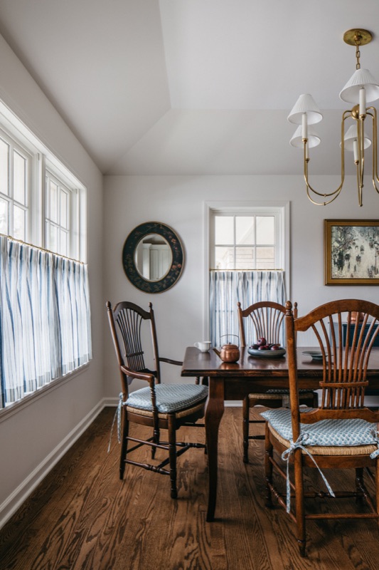 Dining room with antique chairs and crisp cafe curtains · Glenview Main Level Renovation by Leah Phillips Interiors