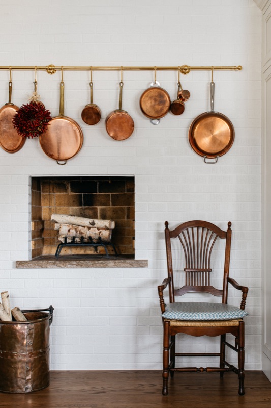 Copper pots hung above the original brick hearth · Glenview Main Level Renovation by Leah Phillips Interiors