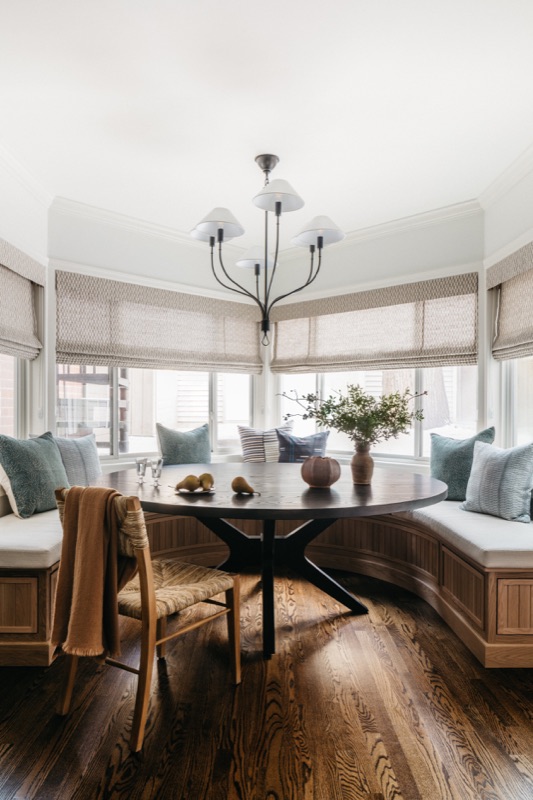 Banquette seating in the bay window with roman shades · Lincoln Park Main Level Renovation by Leah Phillips Interiors