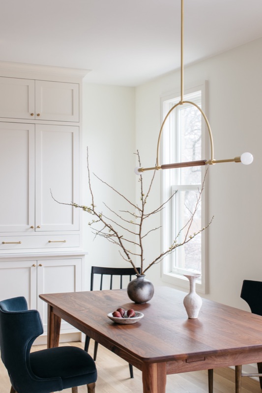 Dining corner with walnut table and navy host chairs · Lincoln Park Renovation