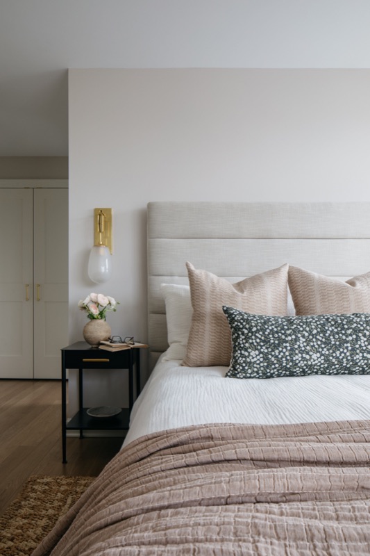 Bedroom with upholstered headboard and layered neutrals · Lincoln Park Renovation by Leah Phillips Interiors