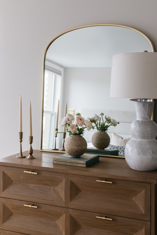 White oak dresser beneath an arched brass mirror · Lincoln Park Renovation by Leah Phillips Interiors