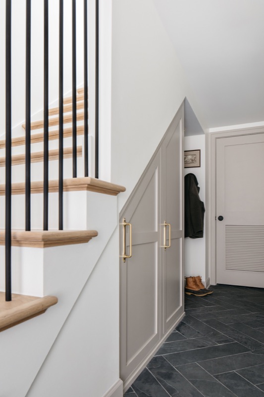 Staircase with black spindles and brass hardware · Lincoln Park Renovation by Leah Phillips Interiors