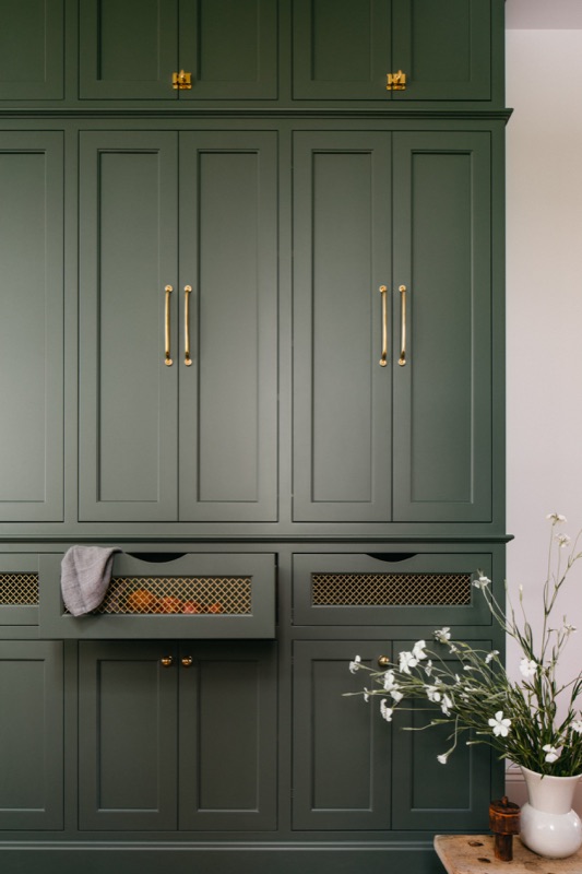 Full-height green pantry wall with brass bin pulls, part of the Oak Park renovation by Leah Phillips Interiors