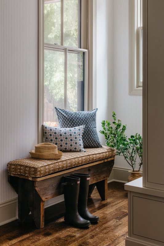 Window seat bench with block print pillows and garden view · Oak Park Main Level Renovation by Leah Phillips Interiors