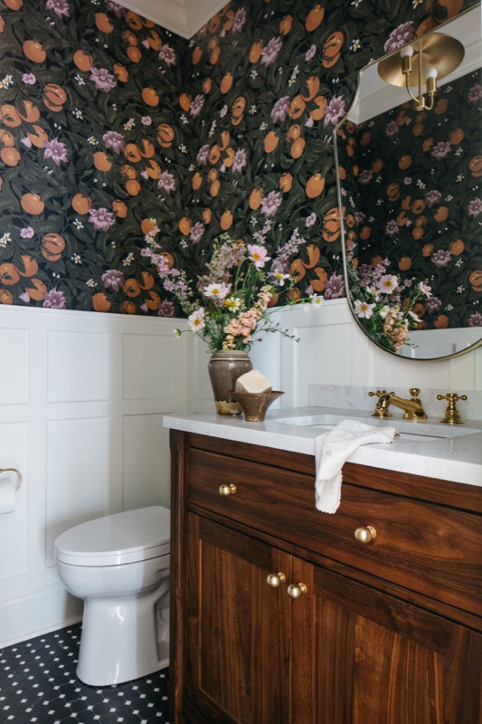 Bathroom with walnut vanity and black penny tile floor · Oak Park Main Level Renovation by Leah Phillips Interiors