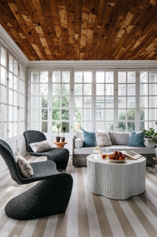 Sunroom lounge with striped rug, dark armchairs and wood ceiling · Oak Park Main Level Renovation
